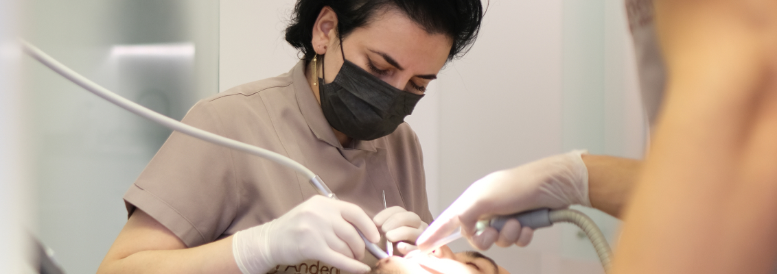Dentista che esegue un controllo estetico su una paziente in clinica moderna